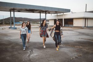 A girl walking with her friends through a parking lot
