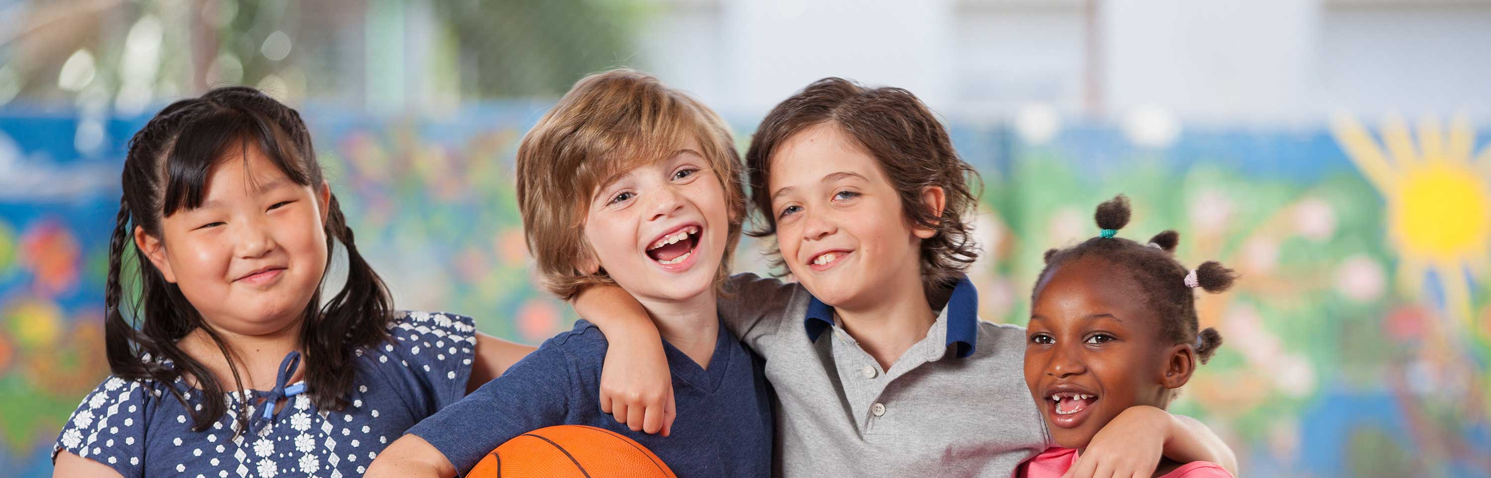 Children playing basketball at the court