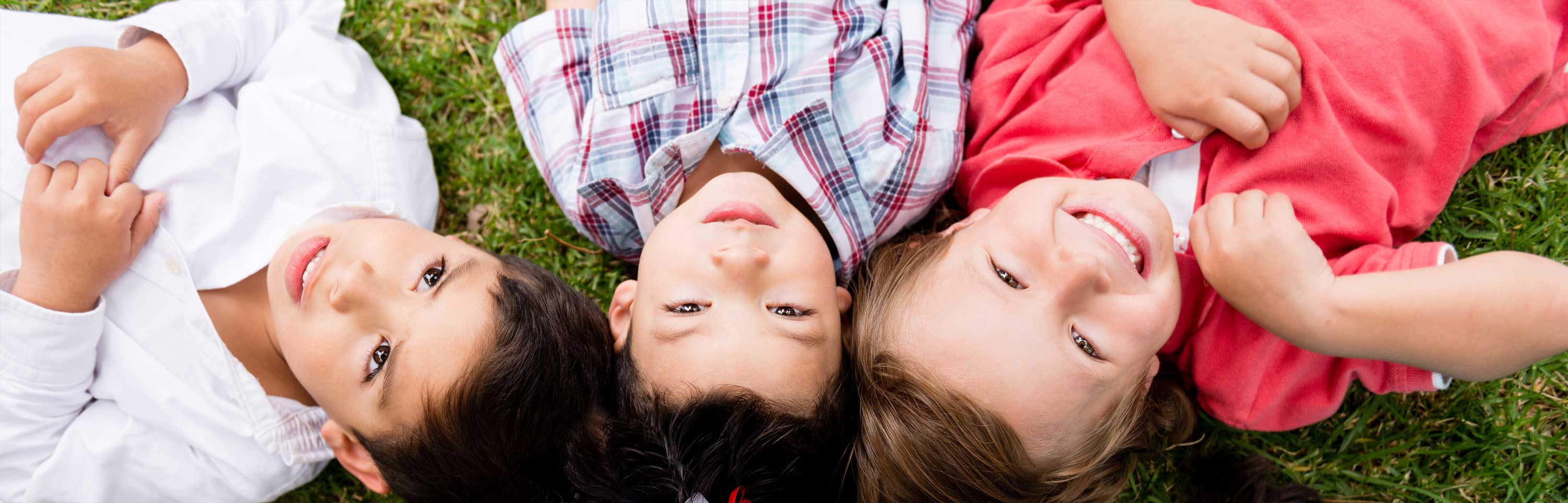 Children lay on the grass at the park